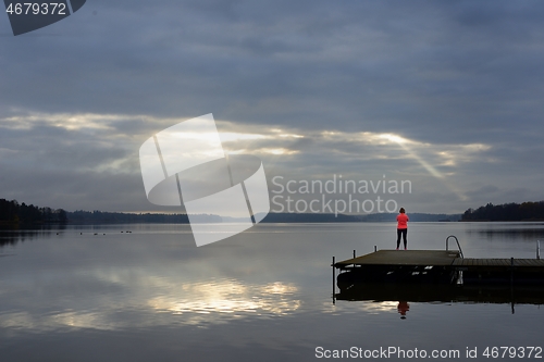 Image of the sun's rays make their way through the clouds above the lake,