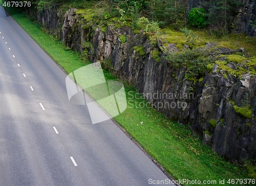 Image of asphalt road along the cliff and forest 