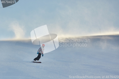 Image of Female snowboarder in sun flare