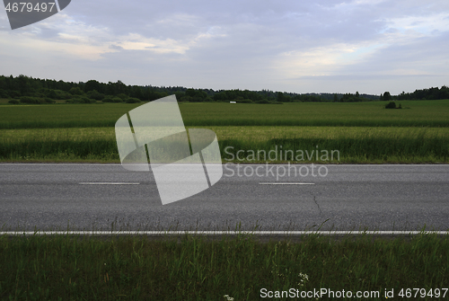 Image of asphalt road along the field somewhere in Finland