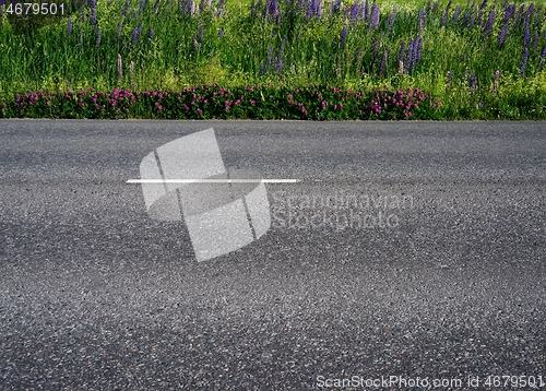 Image of asphalt road along the field somewhere in Finland