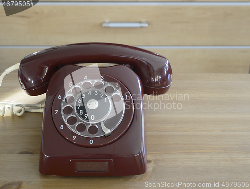 Image of burgundy vintage traditional dial telephone