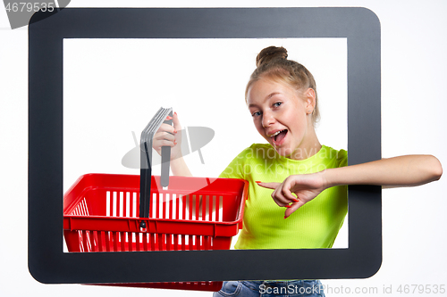 Image of Online shopping concept. Trendy teen girl with empty shopping basket