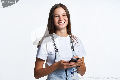 Image of Smiling teen girl with smart phone in hands,