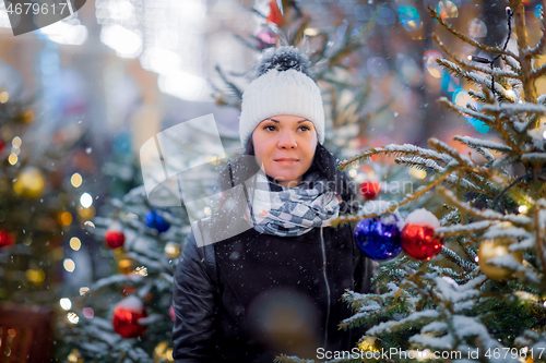 Image of Woman on the street walks on Christmas day next to Christmas tre