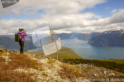 Image of Nature photographer tourist with camera shoots while standing on