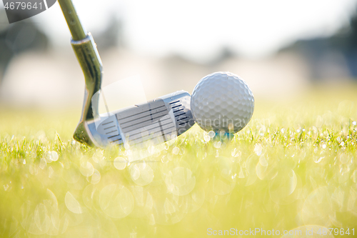 Image of Golf ball on tee in front of driver