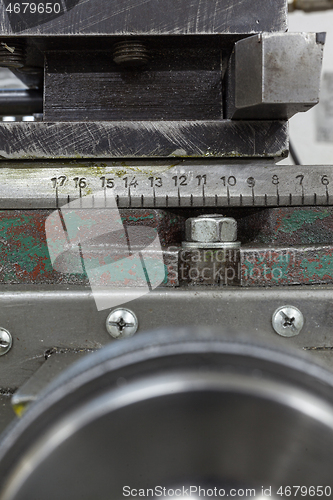 Image of Old yellow lathe machine with a lot of handles.