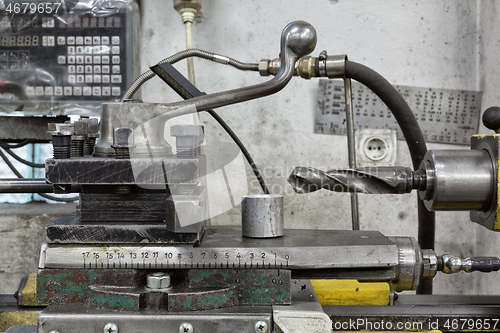 Image of Old yellow lathe drilling machine with a lot of handles.