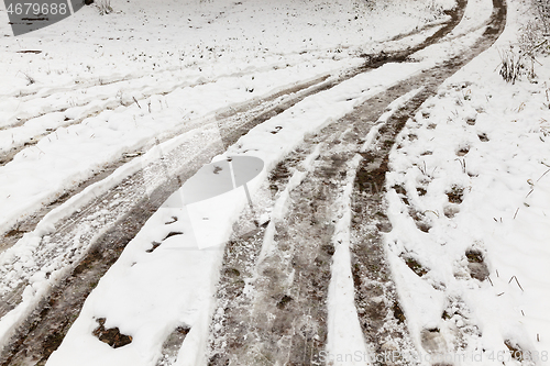 Image of traces of the wheels of the car on a rural road covered with snow