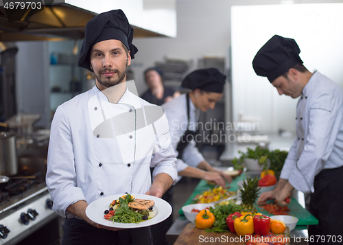 Image of Chef holding dish of fried Salmon fish fillet