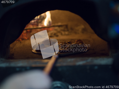 Image of chef removing hot pizza from stove