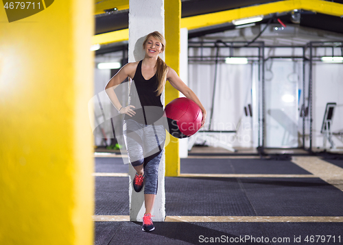 Image of portrait of woman with red crossfitness ball