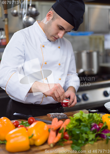 Image of Chef hands preparing marinated Salmon fish