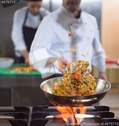 Image of chef flipping vegetables in wok