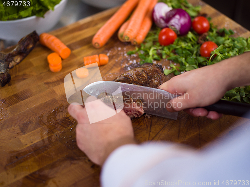 Image of closeup of Chef hands preparing beef steak