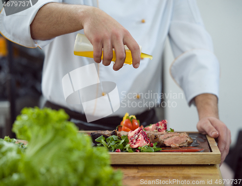 Image of Chef finishing steak meat plate