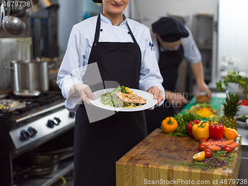 Image of Chef holding dish of fried Salmon fish fillet