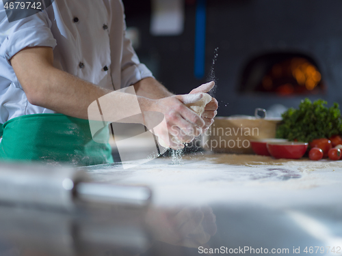 Image of chef hands preparing dough for pizza