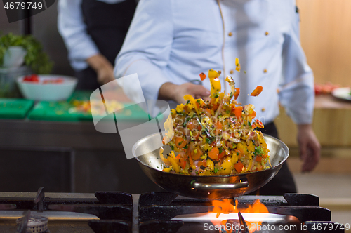 Image of chef flipping vegetables in wok