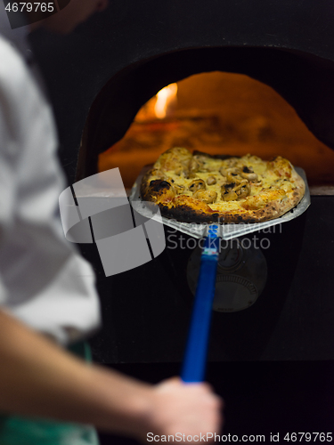 Image of chef removing hot pizza from stove