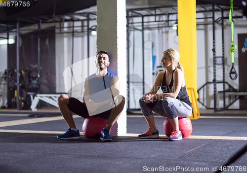 Image of young athletes sitting on the crossfitness ball and relaxing