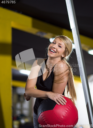 Image of portrait of woman with red crossfitness ball