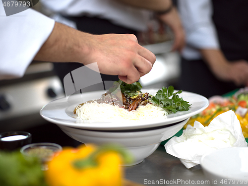 Image of Chef hands serving spaghetti