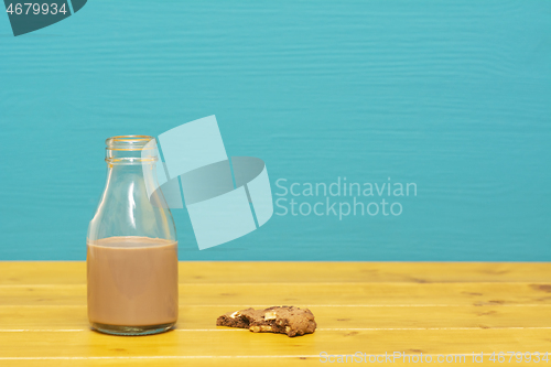 Image of Bottle half full with chocolate milkshake with a half-eaten cook