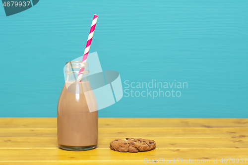 Image of Chocolate milkshake with straw in a bottle with a cookie