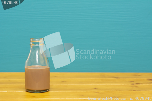 Image of Glass milk bottle half full with chocolate milkshake