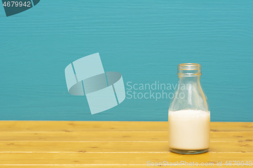 Image of One-third pint glass bottle half full with fresh creamy milk