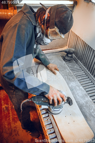 Image of Carpenter using circular saw for cutting wooden boards.