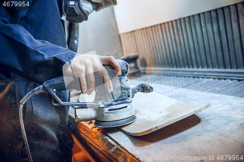 Image of Carpenter using circular saw for cutting wooden boards.