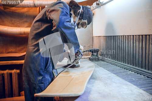 Image of Carpenter using circular saw for cutting wooden boards.