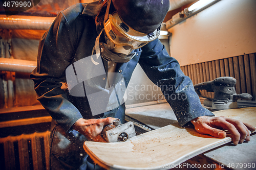 Image of Carpenter using circular saw for cutting wooden boards.