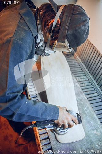 Image of Carpenter using circular saw for cutting wooden boards.