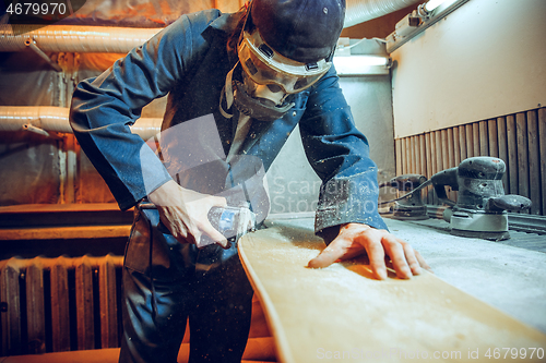 Image of Carpenter using circular saw for cutting wooden boards.