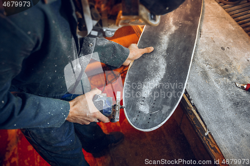 Image of Carpenter using circular saw for cutting wooden boards.