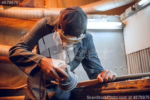 Image of Carpenter using circular saw for cutting wooden boards.