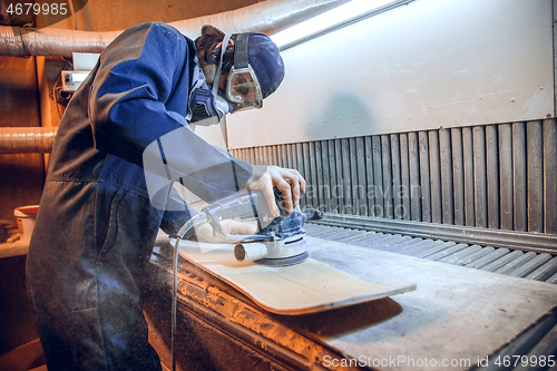 Image of Carpenter using circular saw for cutting wooden boards.