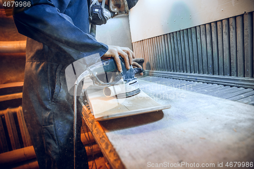 Image of Carpenter using circular saw for cutting wooden boards.