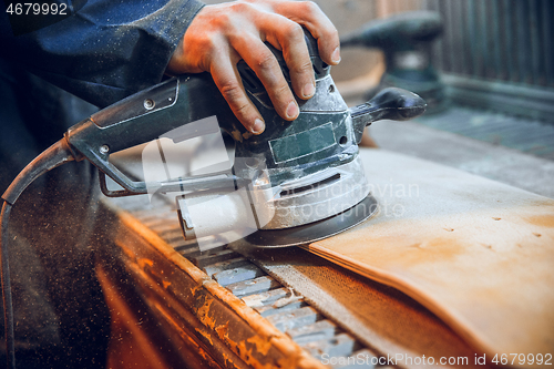 Image of Carpenter using circular saw for cutting wooden boards.