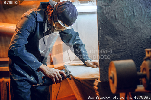 Image of Carpenter using circular saw for cutting wooden boards.