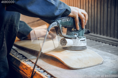 Image of Carpenter using circular saw for cutting wooden boards.