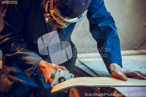 Image of Carpenter using circular saw for cutting wooden boards.