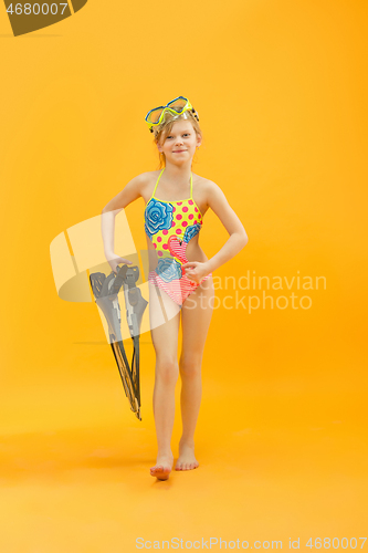 Image of Girl wearing swimwear standing with snorkelers and flippers