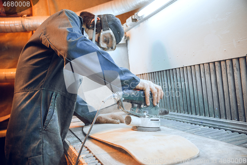 Image of Carpenter using circular saw for cutting wooden boards.