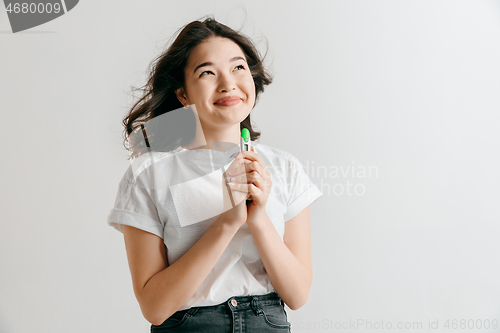 Image of Smiling young woman looking on pregnancy test