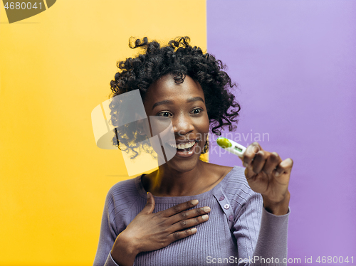 Image of Smiling young woman looking on pregnancy test